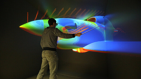 Photo of scientist interacting with 3D visualization of an airplane.