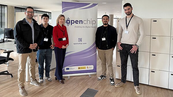 Team members stand in front of an Openchip banner in an office meeting space.