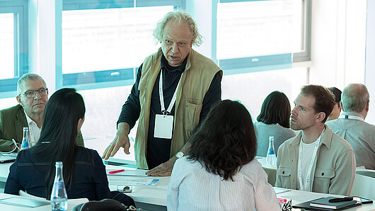 Group discussion in the HLRS auditorium, with a man standing in the middle.