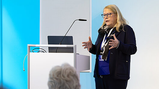 A woman speaks at a podium.