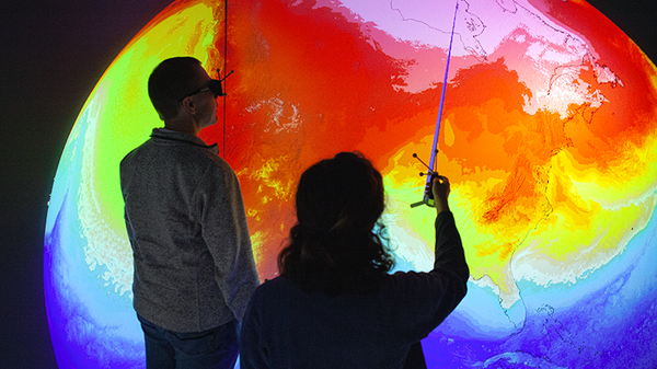 Two scientists observe a visualization of global weather in the HLRS CAVE.