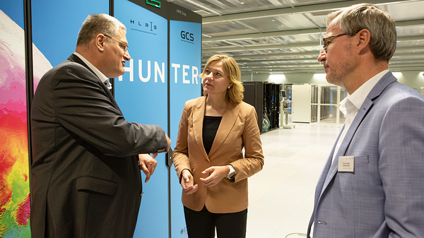 Michael Resch, Henna Virkkunen and Peter Middendorf in conversation in front of the Hunter supercomputer at HLRS.