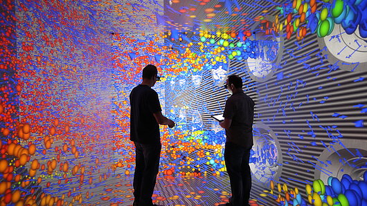 Photo of scientists observing fluid dynamics visualization in the HLRS CAVE.