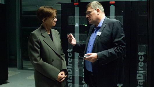 Ein Foto zeigt Ministerin Stark-Watzinger in Gespräch mit Prof. Michael Resch im Rechenraum des HLRS.