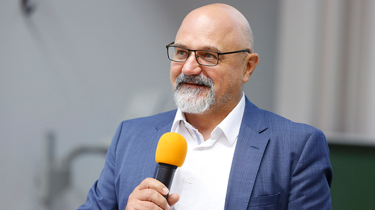 Photograph of Luciano Rezzolla holding a microphone