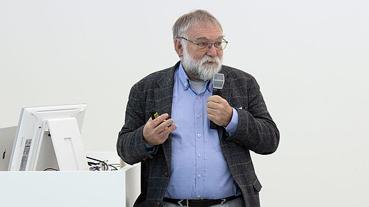 A man holds a microphone while giving a speech
