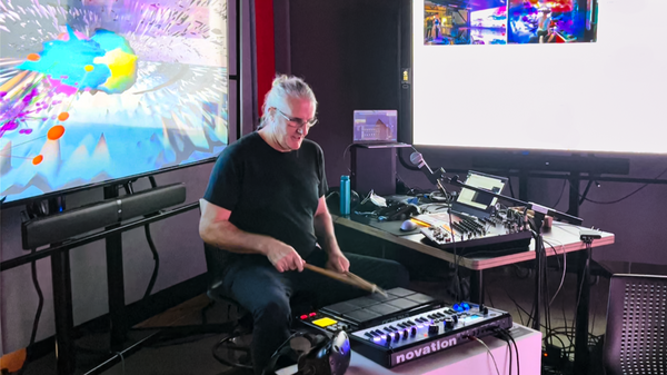 Photo of Dr. Jeremy Ham playing electronic drums in his studio.