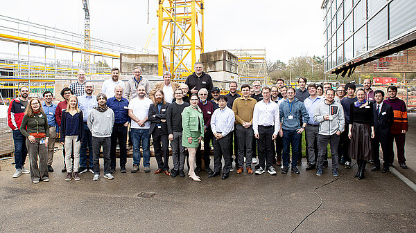 Gruppenfoto der Veranstaltungsteilnehmer:innen vor dem HLRS-Gebäude vor der Baustelle für HLRS III.