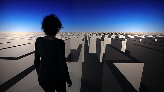 A visitor navigates through a virtual labyrinth in Regina Silveira's artwork "Infinities."