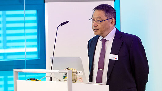 A speaker gives a lecture at a podium.