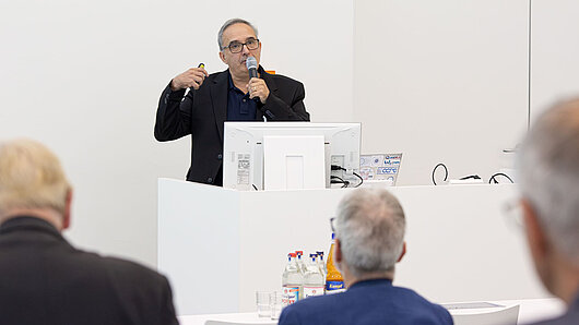 A man gives a lecture at a podium.