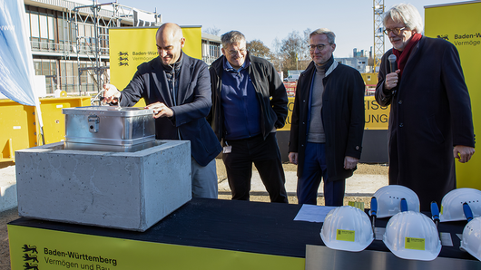 Danyal Bayaz legt die Zeitkapsel in den Grundstein.