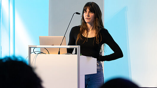 A woman speaks at a podium.
