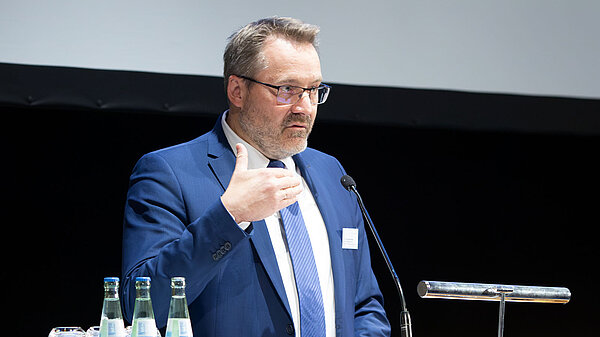 Ein Mann hält vom Rednerpult aus eine Rede.