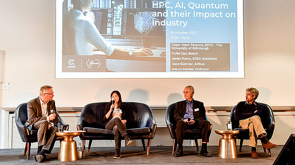 Photo of four speakers sitting onstage.