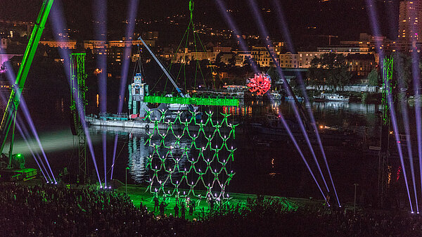 Photo of nighttime performance of La Fura dels Baus with acrobats and lights