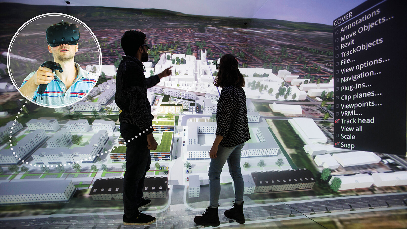 Photo of scientists oberving aerial visualization of city. in an inset, another wears a VR headset.