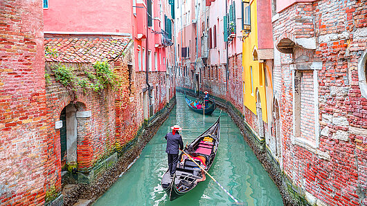 Zwei Boote fahren durch einen Kanal in Venedig, Italien.