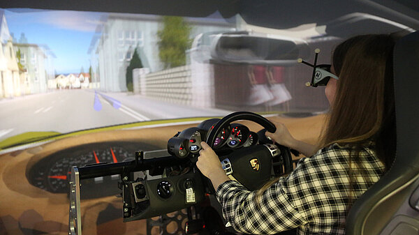 Photo of young woman in a driving simulator.