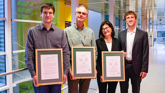 Portrait of staff members holding certificates.