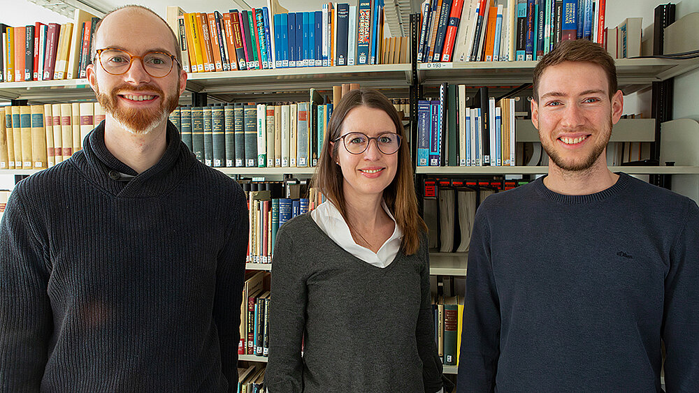 Group photo in a library in front of a bookshelf.