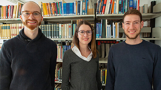 Group photo in a library in front of a bookshelf.