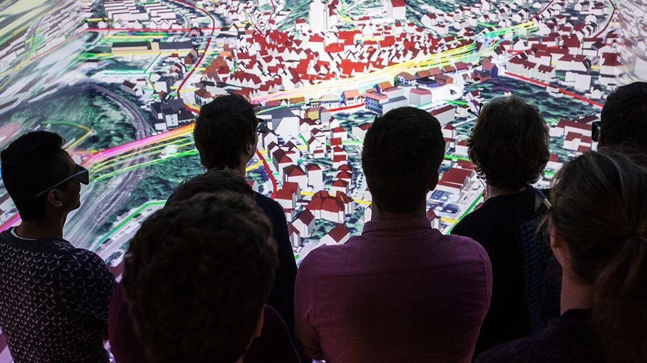 Photo of people observing 3D visualization showing aerial view of downtown Herrenberg.