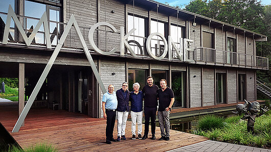 Foto des Teams vor dem MACK One Gebäude