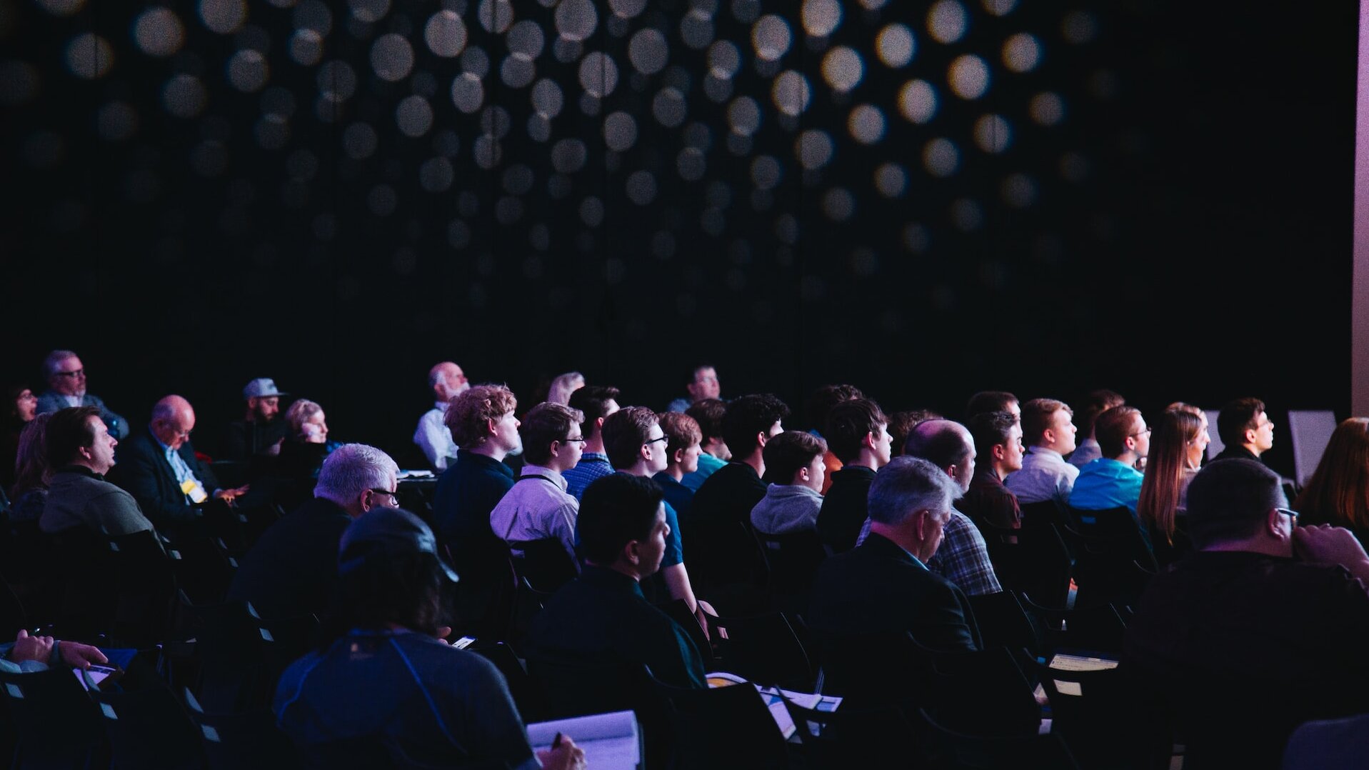 crowd of people sitting in rows participating in an event