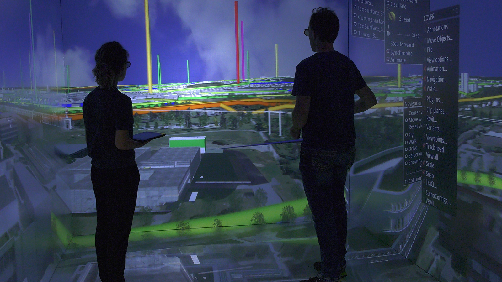 Zwei Wissenschaftler betrachten eine raumgroße 3D-Visualisierung des Universitätsgeländes in Stuttgart.