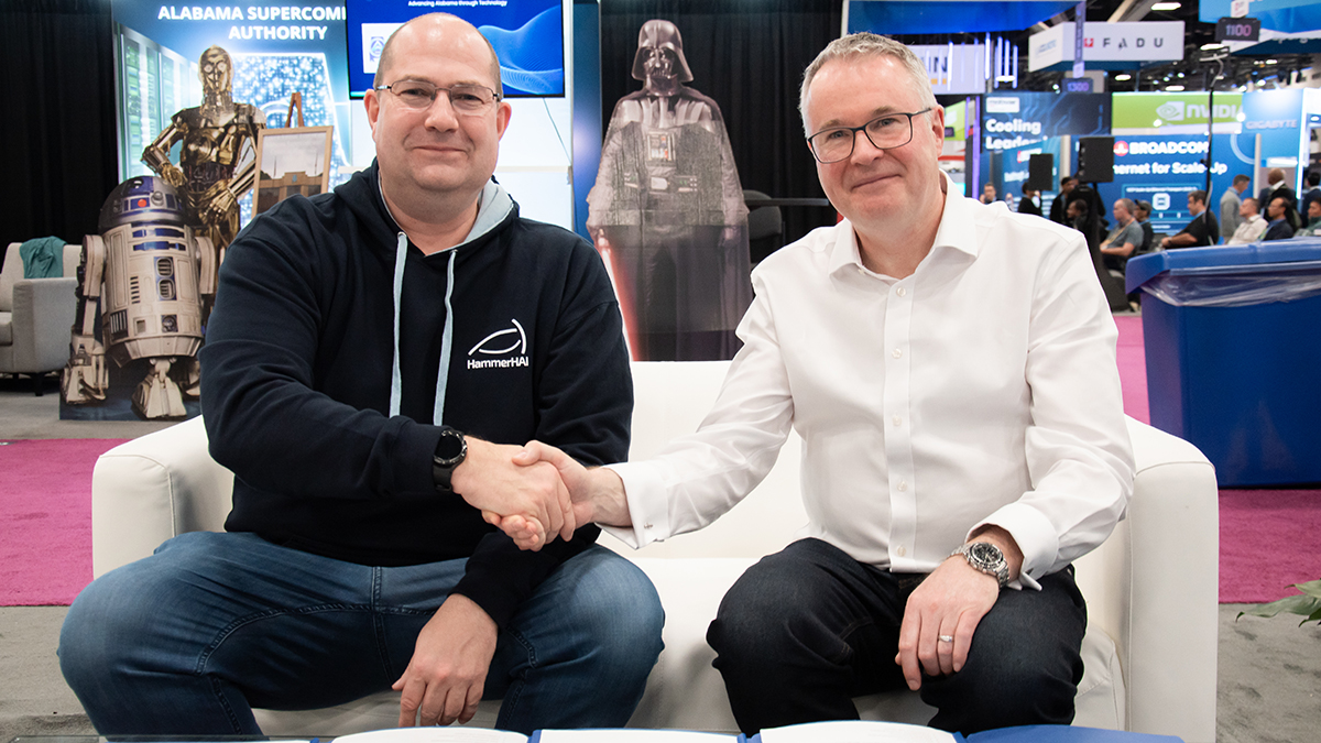 Bastian Koller and Mark Parsons shake hands following the contract signing on the SC25 convention floor.