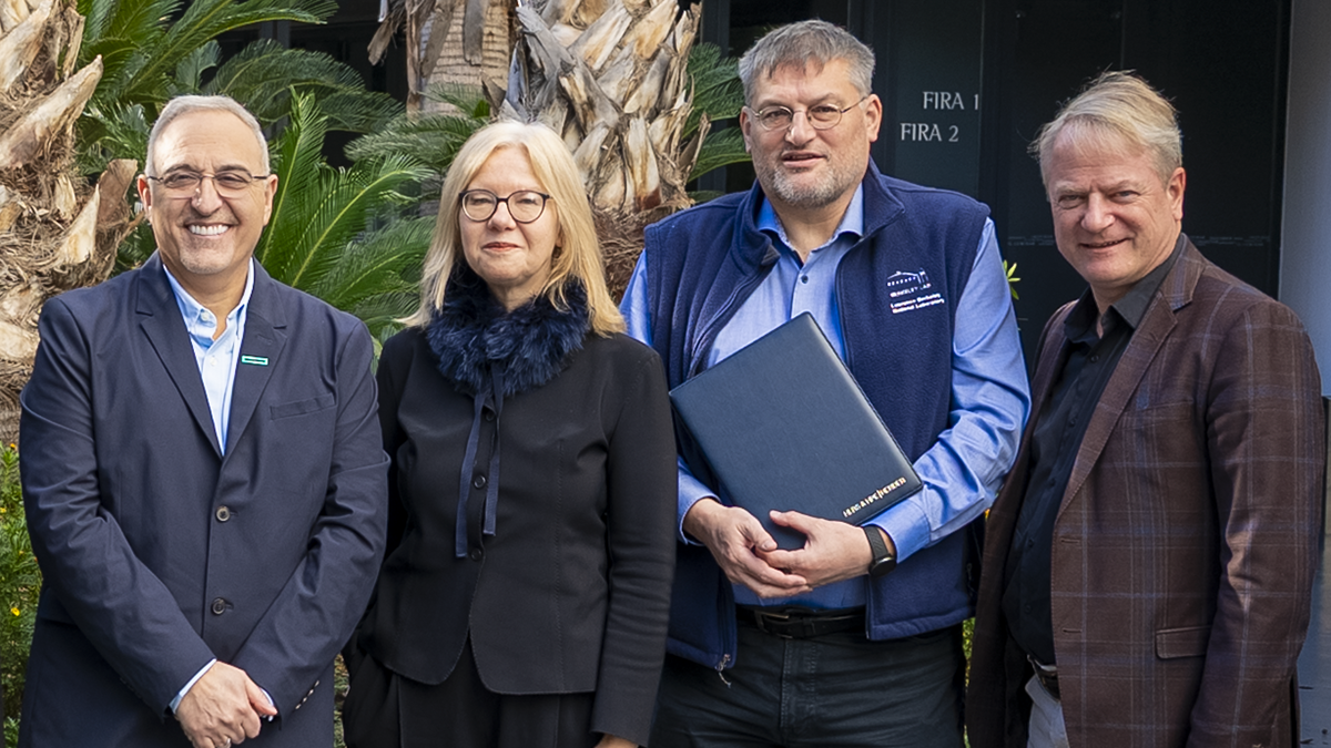 Group photograph, with Prof. Michael Resch holding a copy of the signed contract.